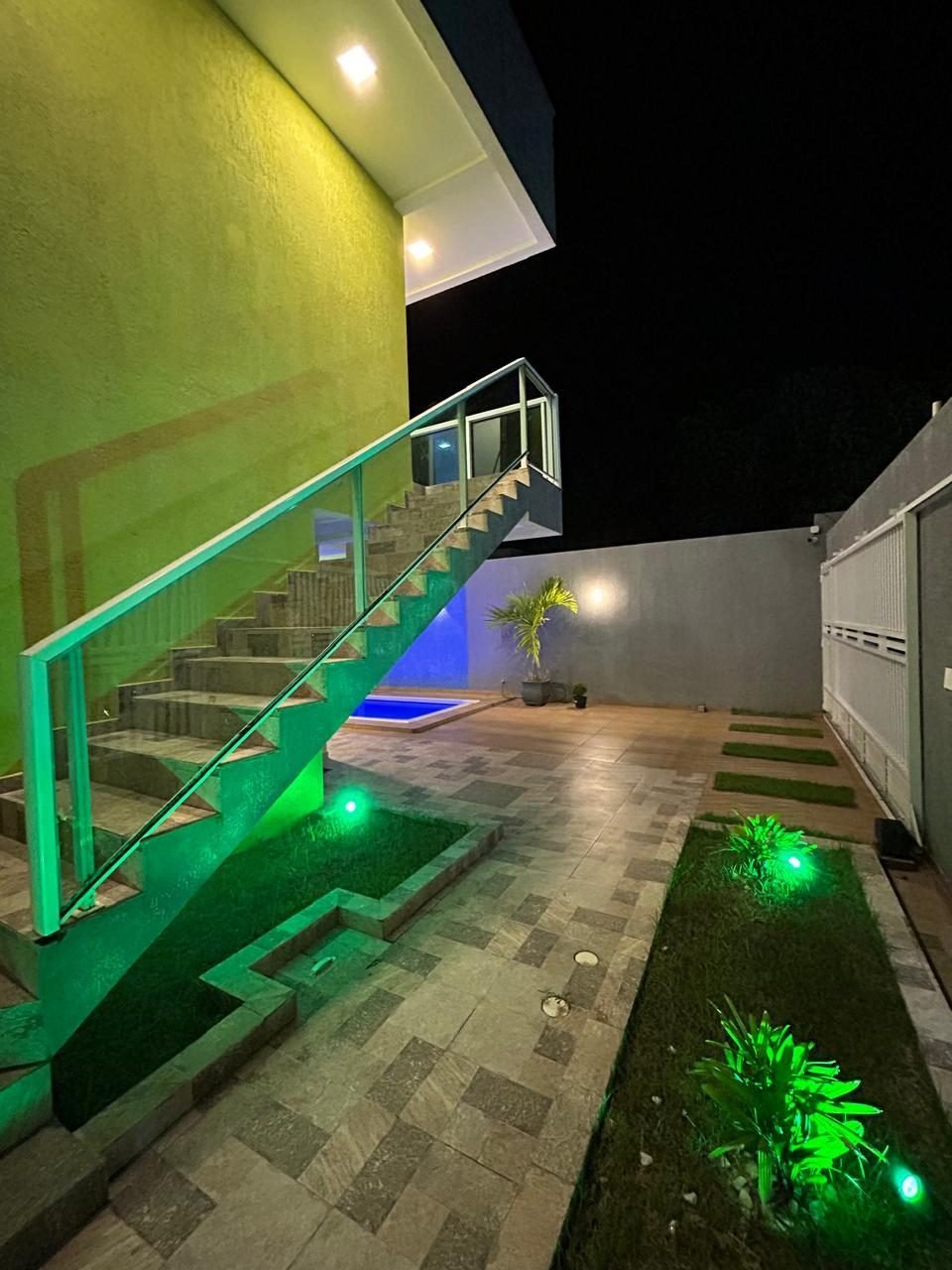 Jardim iluminado e escada de acesso ao pavimento superior