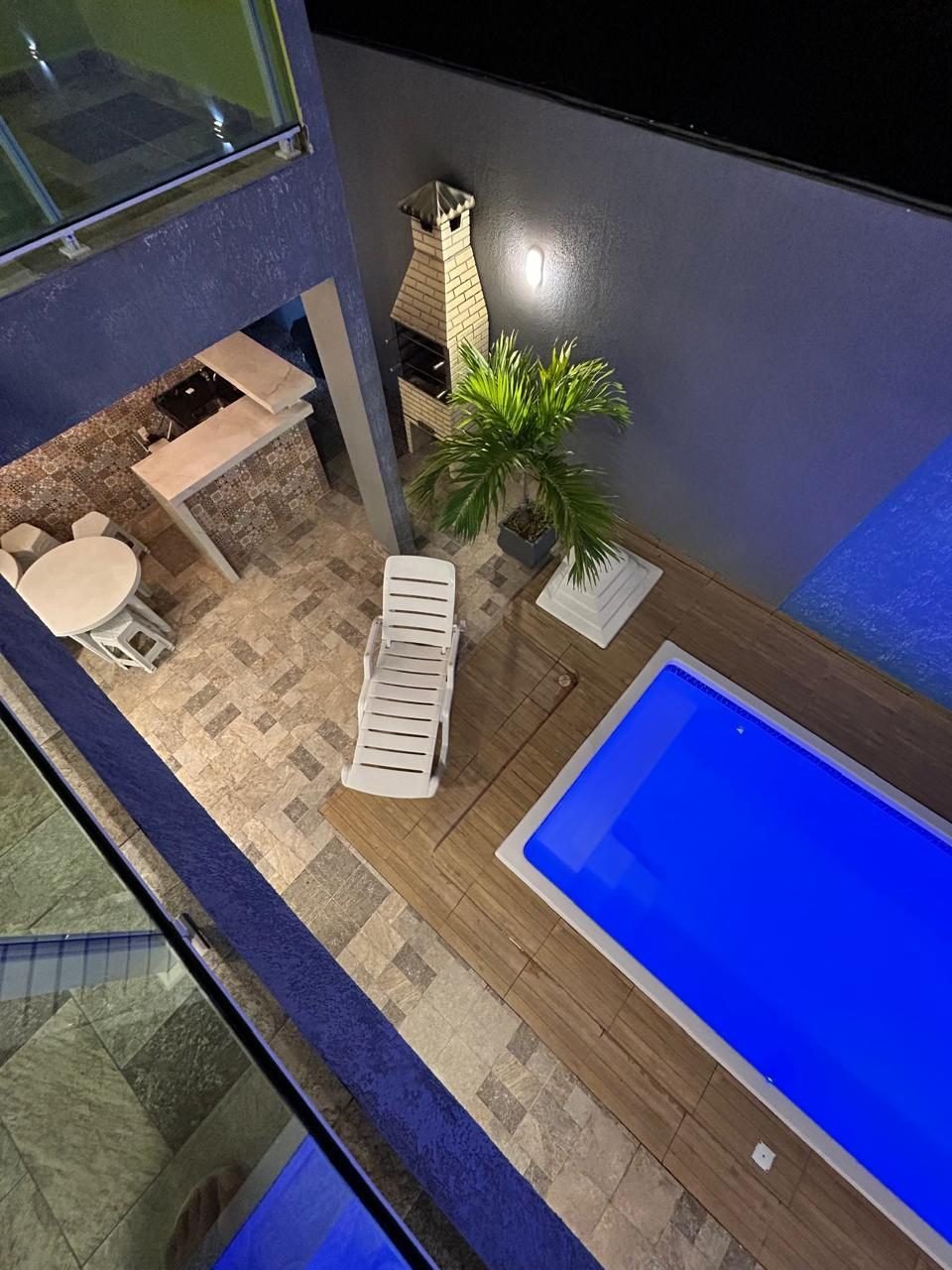 Vista de cima da piscina, deck e churrasqueira