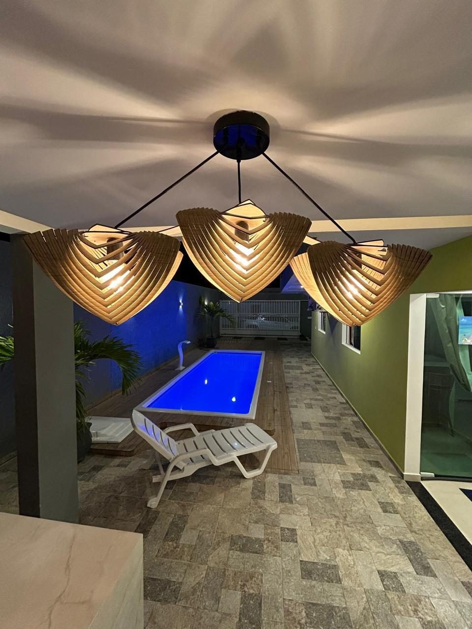 Piscina iluminada à noite vista da área coberta